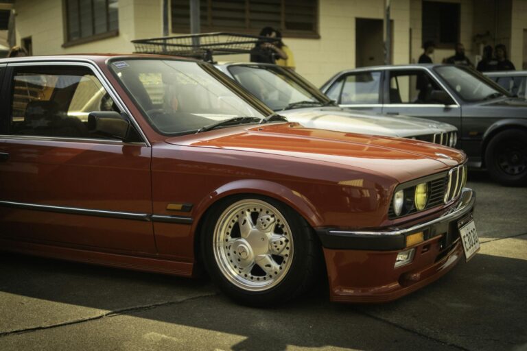 Classic BMW E30 coupe showcased at a Brisbane car event, featuring vintage design and euro car enthusiasts.